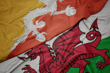 waving colorful flag of wales and national flag of bhutan.