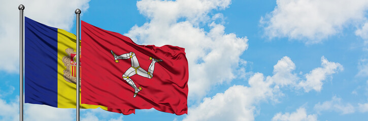 Andorra and Isle Of Man flag waving in the wind against white cloudy blue sky together. Diplomacy concept, international relations.