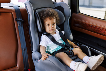 Boy in a car seat. Cute little toddler in a baby seat