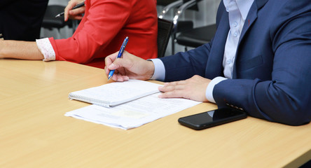 Clouse up business man take note on book during business meeting