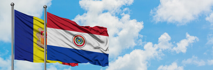 Andorra and Paraguay flag waving in the wind against white cloudy blue sky together. Diplomacy concept, international relations.