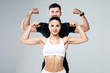 © F8  \ Suport Ukraine - Beautiful athletic couple show biceps on gray background