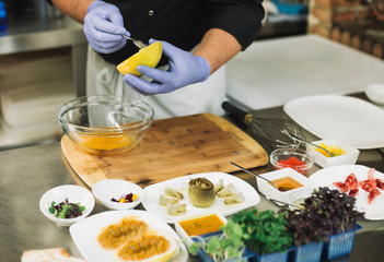 Chef in hotel or restaurant kitchen cooking, only hands, he is working on a new spanish tapa.