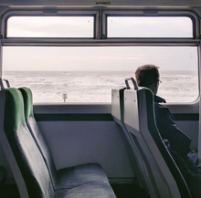 Man Traveling In Train Looking At Sea, Devon UK