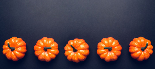 Wall Mural - Dark background with three pumpkins.