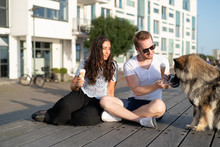 Couple On Boardwalk With Dog Eating Ice Cream