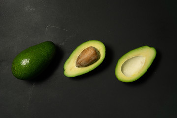 Wall Mural - Fresh, raw avocado sliced on a black