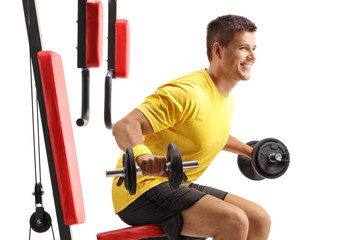 Sticker - Man sitting and exercising with barbells on a fitness gym machine