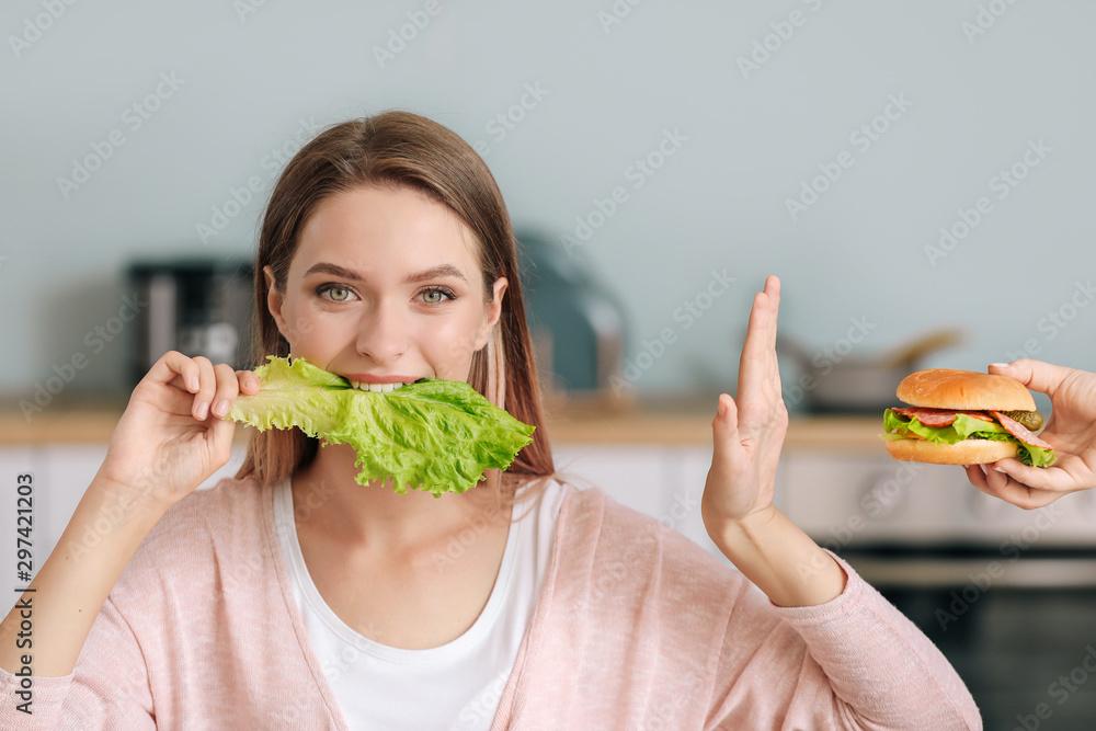 Woman refusing to eat unhealthy food in kitchen. Diet concept