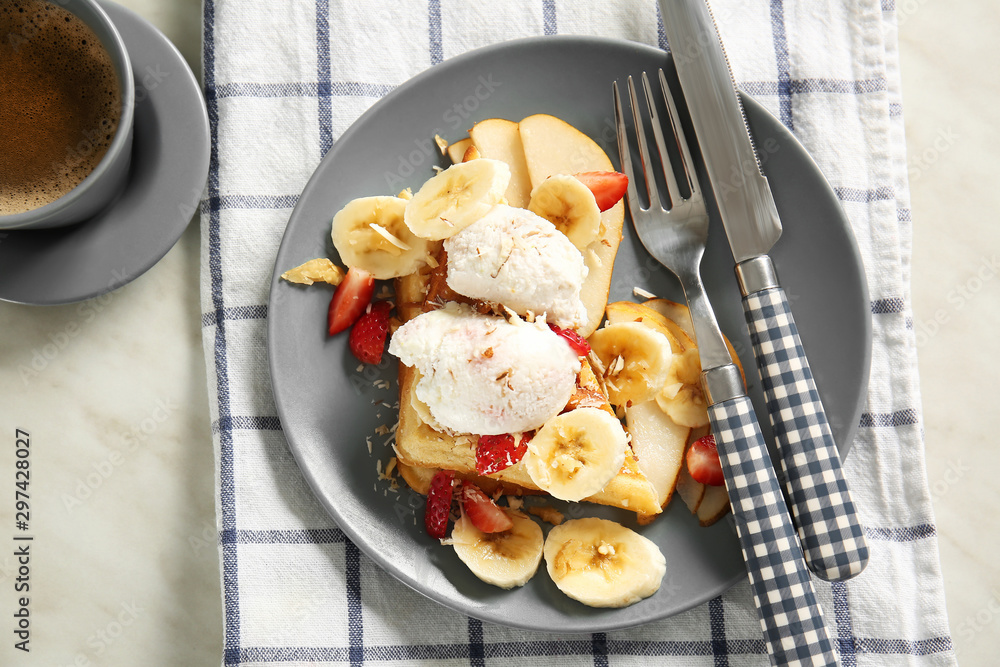 Plate with tasty waffles, ice cream and fruits on table