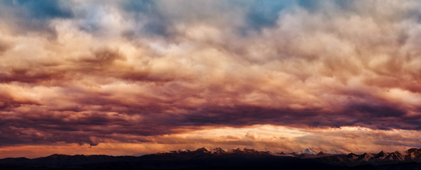 Wall Mural - dramatic light through the clouds against the backdrop of an exciting, vibrant stormy sky at sunset,
