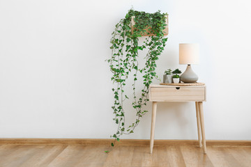 Wall Mural - Table with green houseplants and lamp in room
