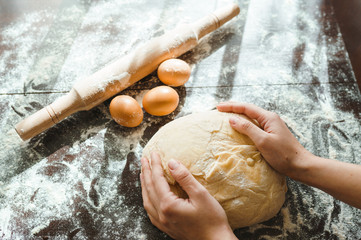 Making dough by female hands on wooden table background. Cooking concept. Lovely female hands.