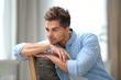 © New Africa - Portrait of handsome young man sitting on chair in room