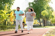 © New Africa - Overweight couple running together in park on sunny day