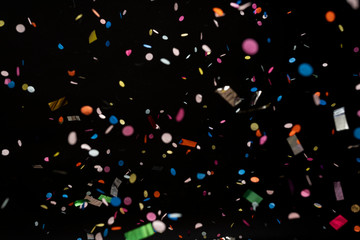 colorful party confetti flying in front of black