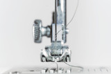 Fototapeta Łazienka - Needle and presser foot of a sewing machine as extreme macro shot, technical invention for the clothing industry, bright background with copy space, selected focus