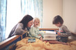 © natalialeb - Candid mother with two children plays in bed