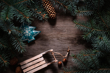 Wall Mural - Christmas frame from fir branches on a background of an old gray board around an open notebook with blank sheets. Frame of fir branches. Christmas card blank concept.