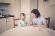 © natalialeb - mother with daughter write and draw at the table