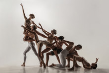 The Group Of Modern Ballet Dancers. Contemporary Art Ballet. Young Flexible Athletic Men And Women In Ballet Tights. Studio Shot Isolated On White Background. Negative Space.