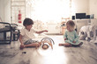 © natalialeb - boy and girl playing on floor with wooden rainbow