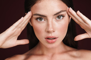 Canvas Print - Image of half-naked woman touching her temples and looking at camera