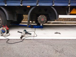 Replacement of a flat tire on a highway truck semitrailer.Removed tire from wheel disc on truck. Tire puncture on highway.