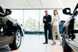 © LIGHTFIELD STUDIOS - selective focus of man and woman walking in car showroom