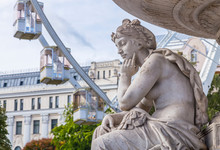 Fragment Of Female Sculpture Of Danubius Fountain On Sziget's Eye Ferris Wheel Background At Erzsebet Square In Budapest, Hungary.