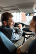 © LIGHTFIELD STUDIOS - selective focus of happy bearded man holding steering wheel and looking at woman in car