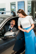 © LIGHTFIELD STUDIOS - young and attractive woman standing near excited man in car
