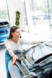 © LIGHTFIELD STUDIOS - selective focus of cheerful woman touching black car