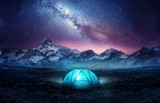 Fototapeta Fototapety góry  - Camping in the mountains under the stars. A tent pitched up and glowing under the milky way. Photo composite.