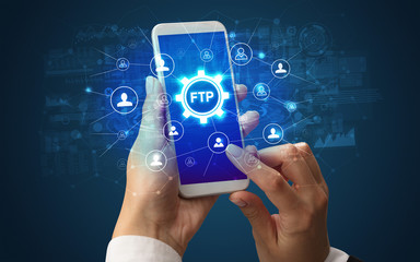 Female hand holding smartphone with FTP abbreviation, modern technology concept