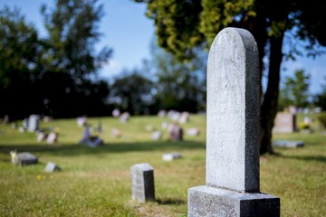 Sticker - Closeup shot of a gravestone with a blurred background at daytime