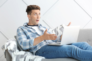 Sticker - Shocked young man with laptop at home