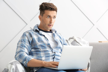 Sticker - Shocked young man with laptop at home