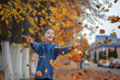 © Volha Zaitsava - Handsome happy boy throwing the fallen leaves up, playing in the autumn park.