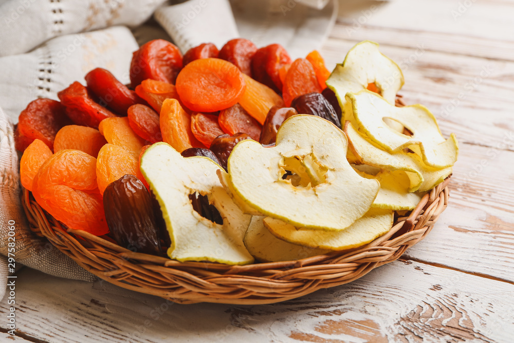Plate with dried fruits on wooden background