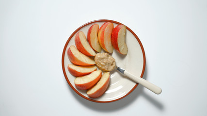 Sliced apples with peanut butter on a plate. Vegetarian breakfast.