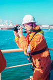 Fototapeta Do akwarium - girl engineer on the ship, inspects the production process