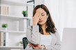 © LIGHTFIELD STUDIOS - exhausted secretary suffering from headache while sitting with closed eyes and holding hand near head