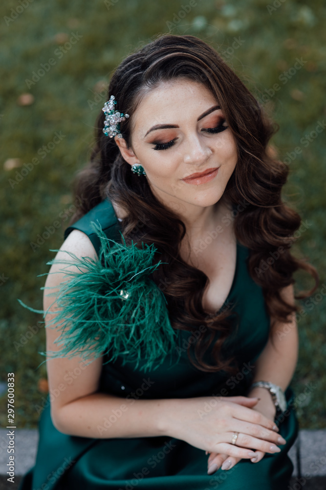 Young pretty lady in green dress. Fashion photo. Beautiful long curly hair woman with closed makeup eyes and manicured nails. Young beautiful stylish girl posing. Female fashion. Stock Photo | Adobe Stock Young pretty lady in green dress. Fashion photo. Beautiful long curly hair woman with closed makeup eyes and manicured nails. Young beautiful stylish girl posing. Female fashion. Stock Photo | Adobe Stock
