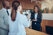 © Flamingo Images - Smiling African American concierge talking with guests during ch