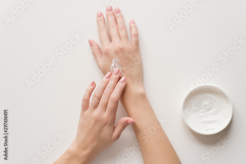 Fotomural The girl distributes moisturizing cream on her hands