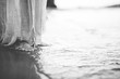 Closeup shot of a person wearing a biblical robe while standing on the shore in black and white