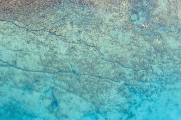 An aerial view of the beautiful Mediterranean sea, where you can se the rocky textured underwater corals and the clean turquoise water of blue lagoon Agia Napa