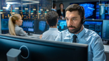 Poster - Customer Service Representative Answer Client's Questions in a Headset. He Works for a Big Technological Company. Office Has Multi-Ethnic Team of Specialists, Displays Show Useful Information.