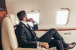 © LIGHTFIELD STUDIOS - back view of businessman in suit looking through window in private plane